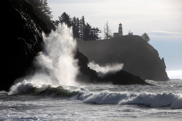 Waves crashing onto rocks along the shore below Cape Disappointment Lighthouse, Waikiki Beach, Cape Disappointment State Park, Washington, USA. January, 2023. 