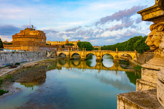 A view of Castel SantAngelo and Ponte SantAngelo, originally the Aelian Bridge or Pons Aelius, in Rome, Italy. The iconic castle and bridge are reflected in the still waters of the Tiber River.