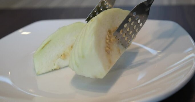 A close up shot of guava salad served with Indian mixed spices green salt on white plate.