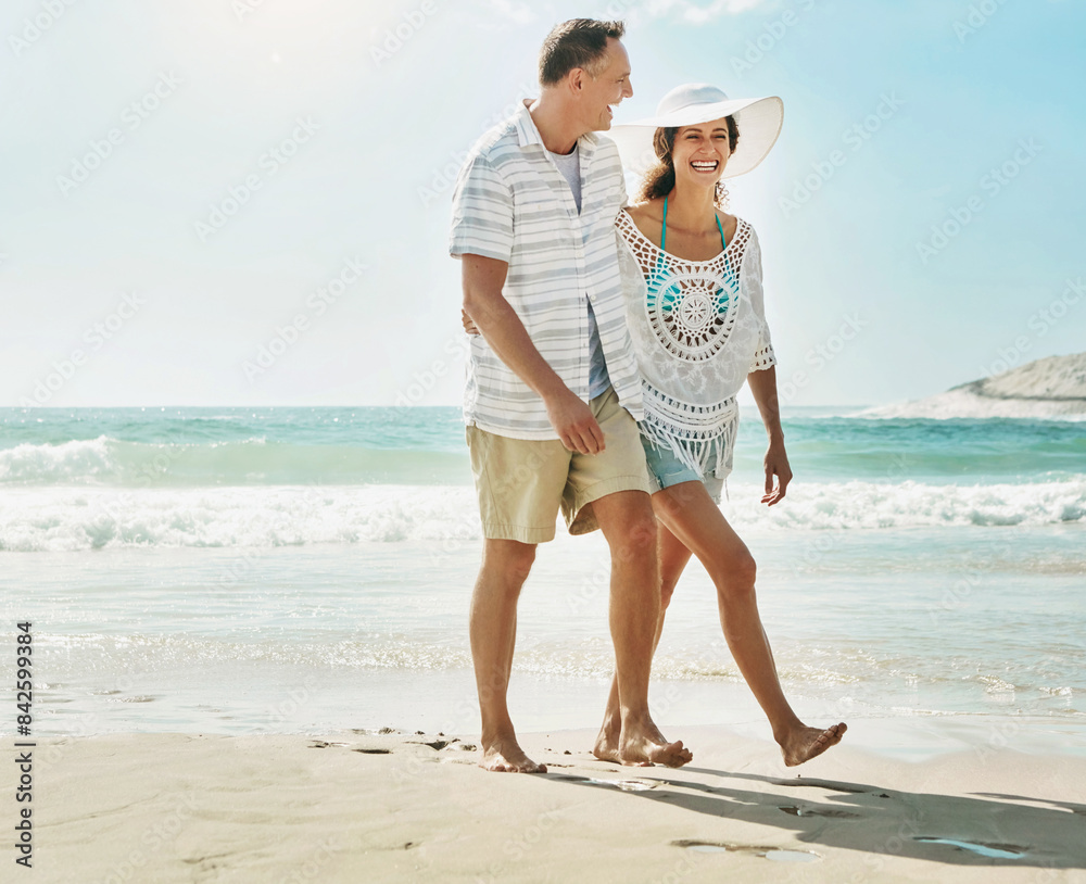 Wall mural Happy, couple and laughter at beach on romantic walk for bonding, love and time together in nature. Smile, man and woman with funny joke about marriage at seashore for commitment and relationship