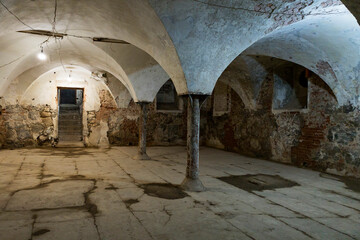 Fototapeta premium A room with stone walls, a white pillar, and an archway