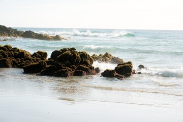 Waves hitting the beach and Rocks on the coast