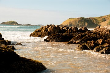 Waves hitting the beach and Rocks on the coast