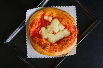 Pizzetta napoletana da bar con sugo di pomodoro e mozzarella cotta al forno e servita per aperitivo in un bar