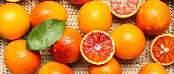 Wicker box with tasty blood oranges as background