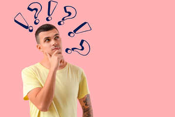 Thoughtful young man on pink background