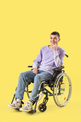 Obraz premium Happy young man in wheelchair on yellow background