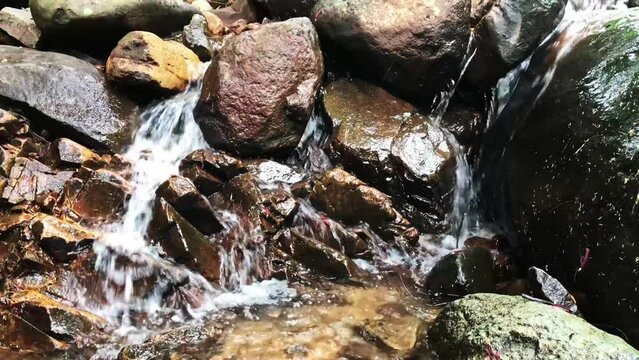 Clear river water falls flowing over rocks, 4k footage for advertising or presentation background, footage of water flowing over rocks