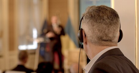 Man using headphones for simultaneous translation at business conference. Importance of global...