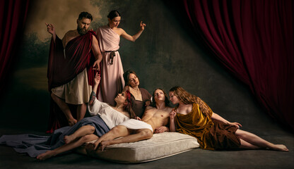 Family moment where father and mother watch their son, lying on matrass, who surrounded by three...