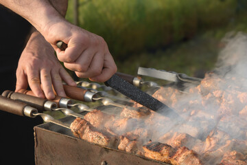 Cutting large pieces of meat for deep-frying over charcoal during cooking