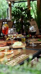 A festive table in a restaurant on a summer terrace with alcoholic drinks and meat and pork food