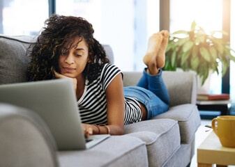 Happy, woman or student with laptop on sofa for distance learning, remote work or online lesson at...