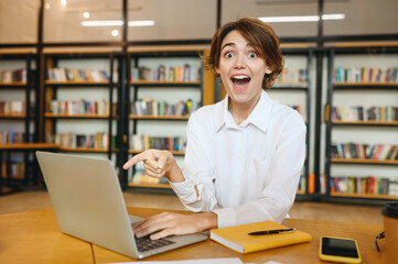 Young surprised shocked happy successful employee IT business woman wearing white shirt casual...