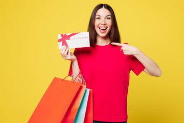 Young woman wears pink casual clothes hold paper package bags after shopping point on store gift...