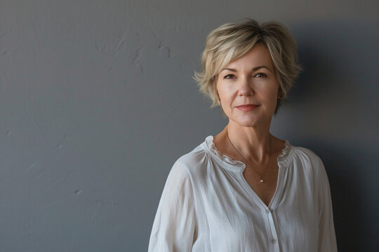 a woman in a white shirt standing against a wall