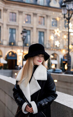 Fototapeta premium Beautiful woman on the street. Happy lifestyle and holiday concept. Woman in a black hat panama