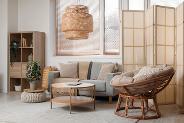 Stylish living room with folding screen, sofa and armchair