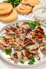 grilled mini pork skewers on a plate, top view