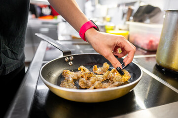 Close-up of a person’s hands skillfully cooking shrimp in a frying pan, showcasing a culinary process. Perfect for restaurant and cooking related content