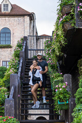 Obraz premium A couple standing together on a flower-adorned staircase, smiling and enjoying a romantic moment.