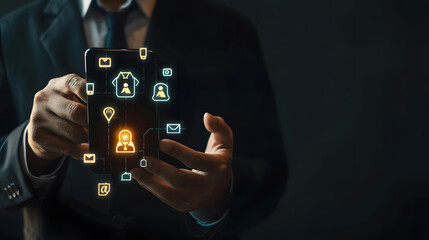 Businessman holding a smartphone with a bell icon and social media icons for a marketing concept on a black background 