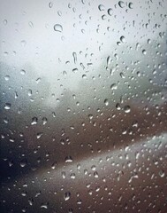 captivating photo of raindrops on a car window, taken from inside the vehicle. This image beautifully captures the serene and reflective mood created by rain, with droplets distorting the view outside
