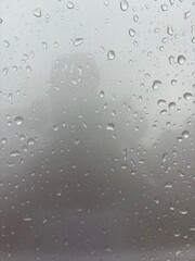 captivating photo of raindrops on a car window, taken from inside the vehicle. This image beautifully captures the serene and reflective mood created by rain, with droplets distorting the view outside