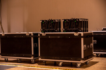 Flightcase of concert music and video equipment stacked behind the stage
