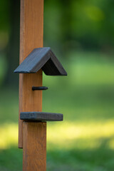 Close view of a wooden bird feeder in the park