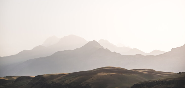 Panorama of a mountain range in the morning at dawn, tonal perspective of mountains in the morning haze in the Pamirs in Tajikistan