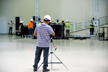An engineer, technical worker working on the installation of a sound system in an auditorium of an...