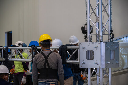 A group of engineers at work assembling a structure for a concert, backstage