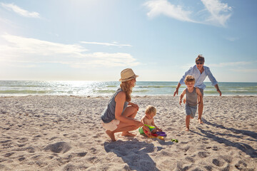 Happy, parents and kids playing on the beach on family vacation, holiday or adventure in summer....