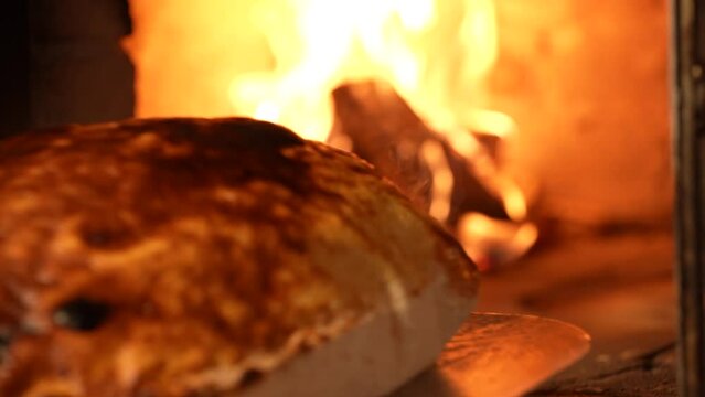 The process of cooking calzone pizza in an oven on fire . Slow motion