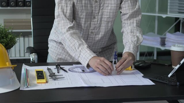 Female architect engineer is drafting blueprints using CAD software, focusing on sustainable infrastructure, renewable energy solutions, and adhering to building codes