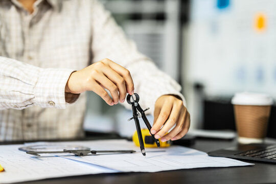 Female architect engineer is drafting blueprints using CAD software, focusing on sustainable infrastructure, renewable energy solutions, and adhering to building codes