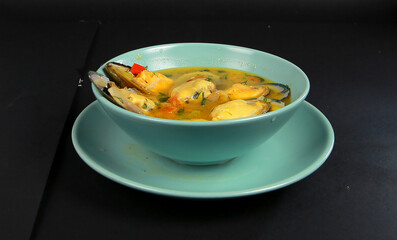 Hot and spicy delicious mussel seafood soup tasty with black background  