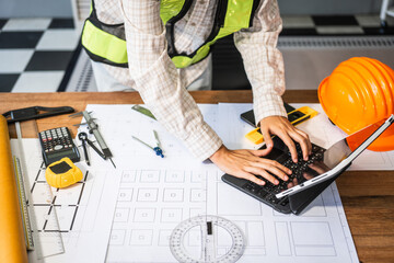 Female architect engineer is drafting blueprints using CAD software, focusing on sustainable infrastructure, renewable energy solutions, and adhering to building codes
