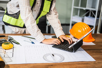 Female architect engineer is drafting blueprints using CAD software, focusing on sustainable...