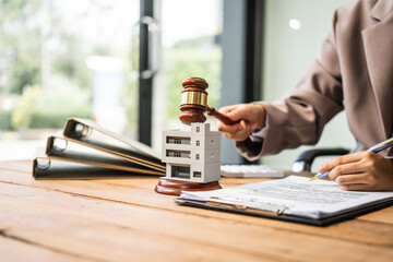 A young businesswoman is working at her desk, managing lease agreements and coordinating with the...