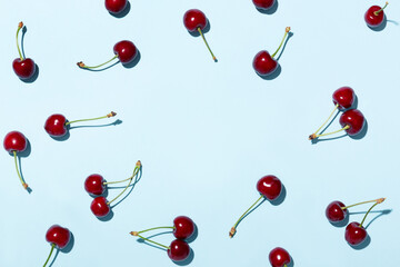 Ripe cherries or sweet cherries on a blue background. Top view. Space for text.