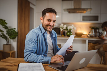 Fototapeta premium man work form home hold document use laptop with son at background