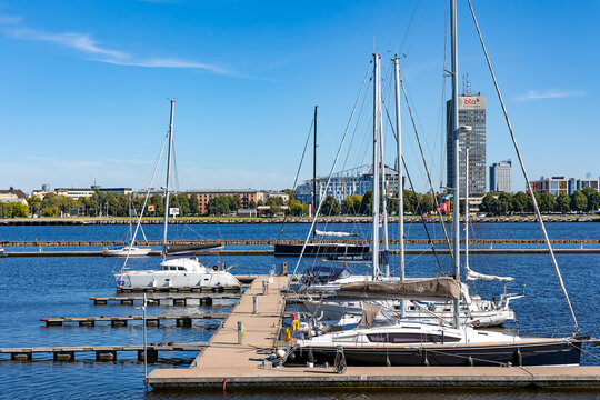 LATVIA, RIGA, 05, JUNE, 2024: Sailing yachts moored near a wooden pier in Daugava river harbor at Kipsala, Riga, Latvia.