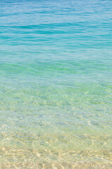 Ripples of the crystal-clear sea waters near the sand of Praia do Dentista, in Ilha Grande, RJ, Brazil.