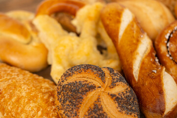 wicker basket overflowing with freshly baked pastries: cheese and poppy seed buns, pretzels, and sweet curd tarts
