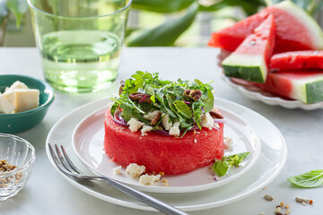 watermelon steak with feta cheese, greens and nuts, fresh raw summer meal