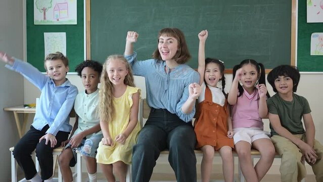 Portrait of a teacher and kids in a classroom where children have pleasure learning.