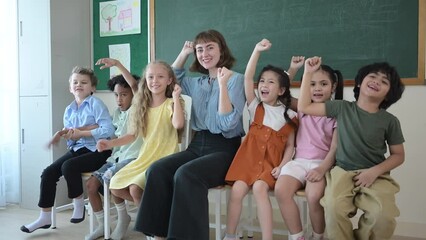 Portrait of a teacher and kids in a classroom where children have pleasure learning.