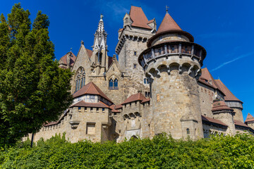 Castle landmark under blue sky. Medieval castle in Austria. Ancient historical sights around Vienna. Castle Kreuzenstein old building from outside © Yuliia